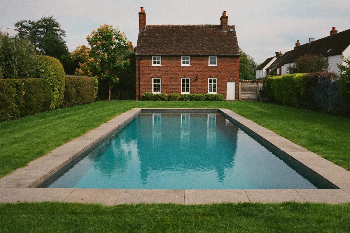 Piscine enterrée dans un jardin de maison en brique