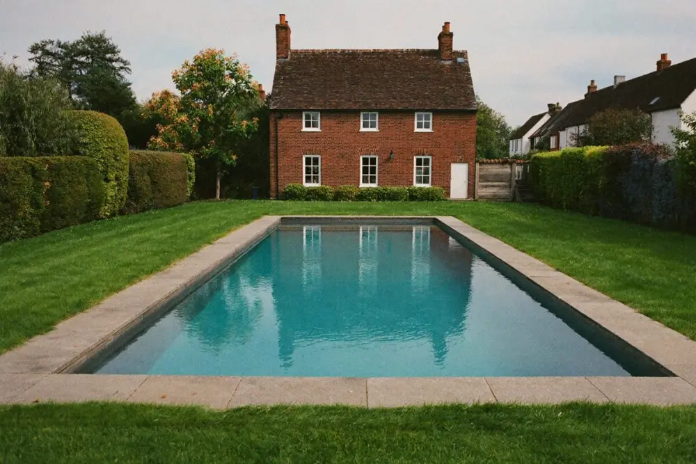 Piscine enterrée dans un jardin de maison en brique