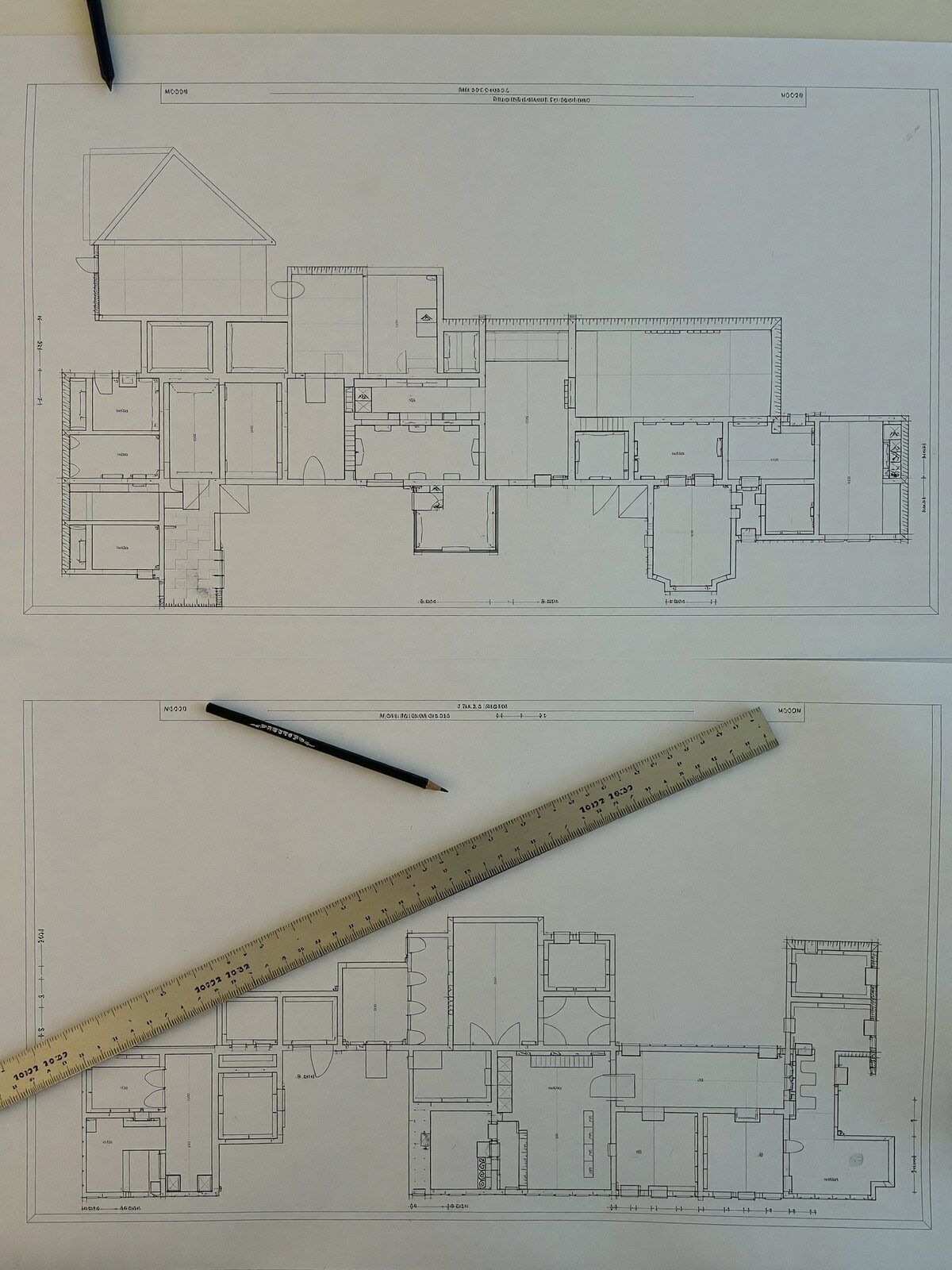 Plans d'architecte étalés sur un bureau, règle et crayon posés dessus