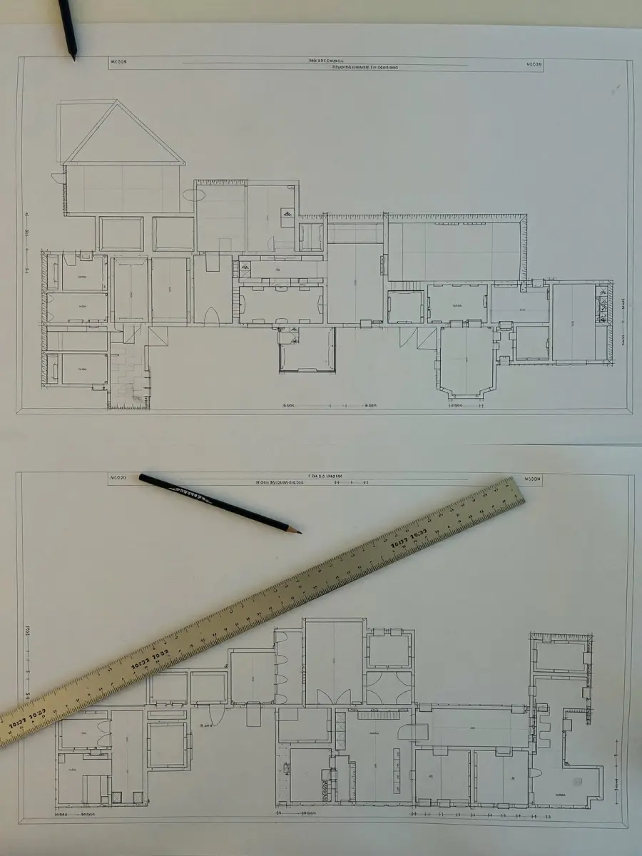 Plans d'architecte étalés sur un bureau, règle et crayon posés dessus